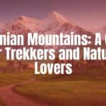 Majestic Armenian mountain landscape, snow-capped peaks against a clear blue sky, lush green valleys with ancient stone ruins, a winding hiking trail, cinematic lighting, realistic photography style.