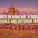 A vibrant summer landscape of Armenia featuring a historic stone monastery on a green hillside, distant snow-capped mountains, colorful wildflowers, and people celebrating at an outdoor festival with traditional food and music, bright sunny lighting, cinematic style.